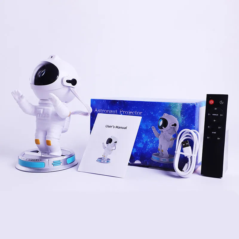 White Exit Astronaut Starlight Projection Lamp with USB cable and remote control on a table, projecting a blue starry light effect