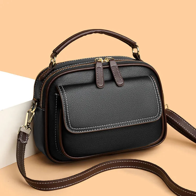 Black women's cross-body PU shoulder bag with adjustable straps showing its square shape and size.