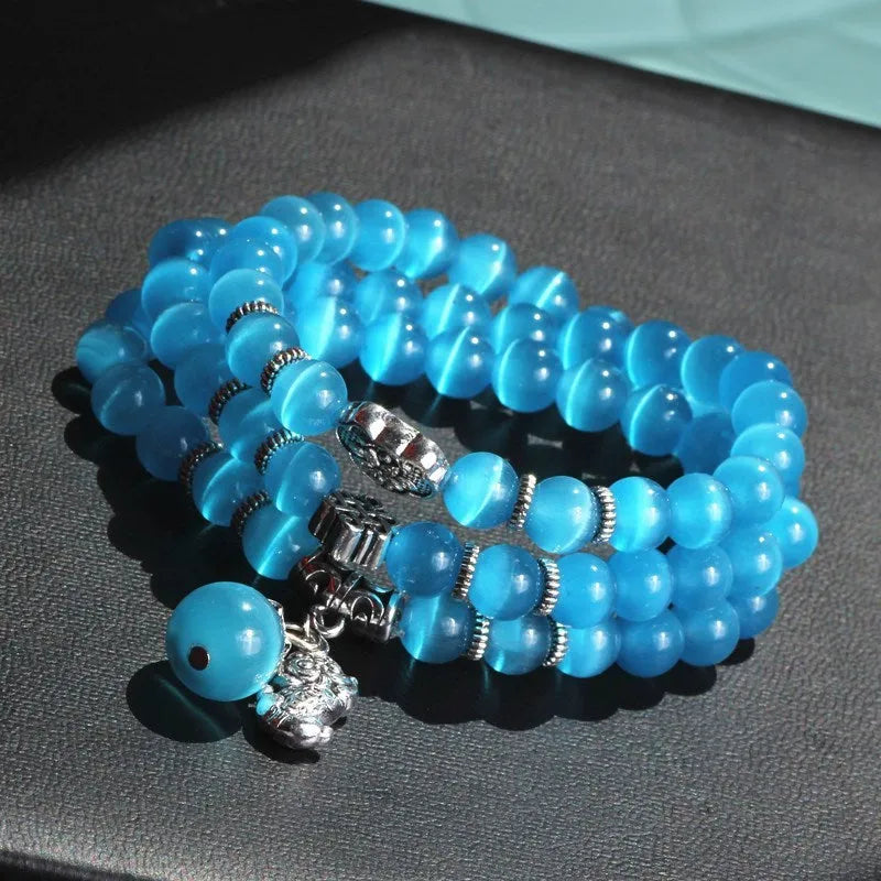 Opal crystal cat eye bracelet with lucky cat charm, shown in one of six colour options.