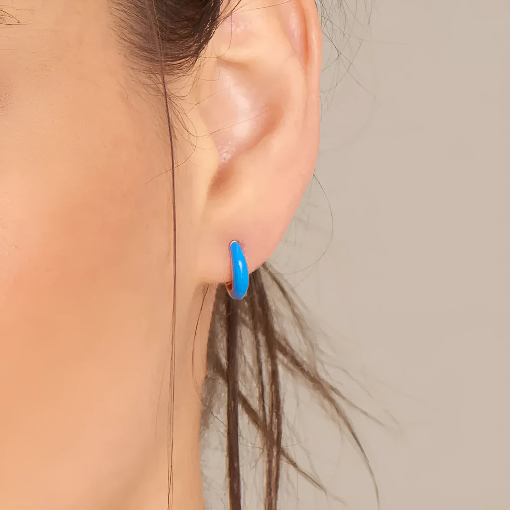 Oval-shaped curved drop earrings with colourful epoxy resin drip finish and silver metal pin.