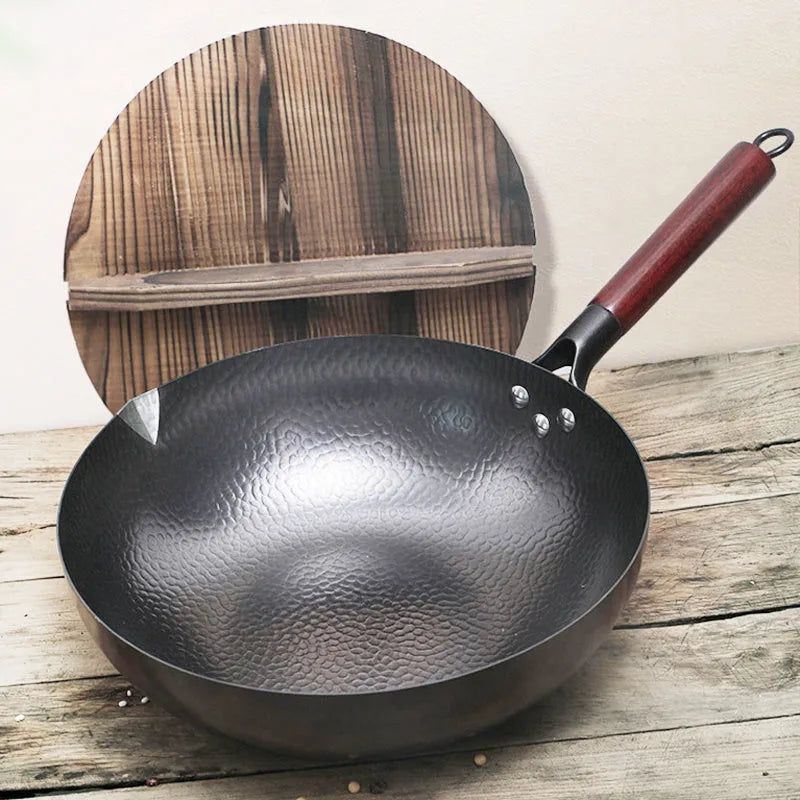 Black traditional iron wok pan with wooden handle, 32cm diameter with matching lid.