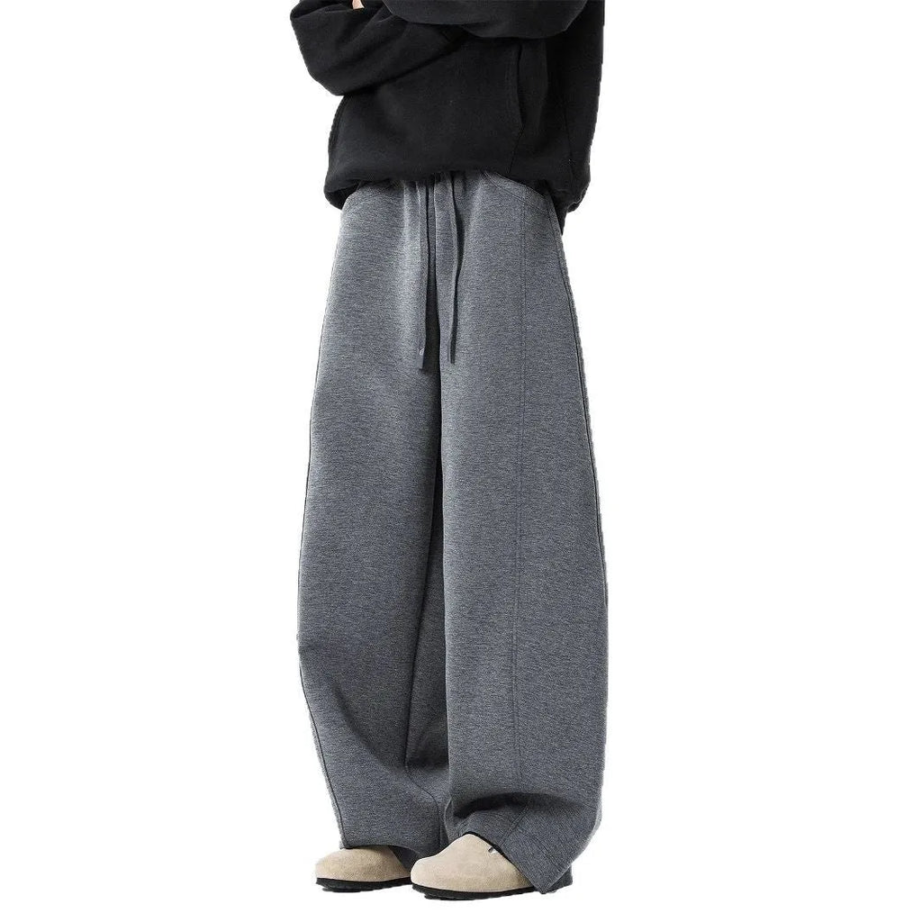 Men’s relaxed fit dark gray trousers with drawstring waist and belt on model