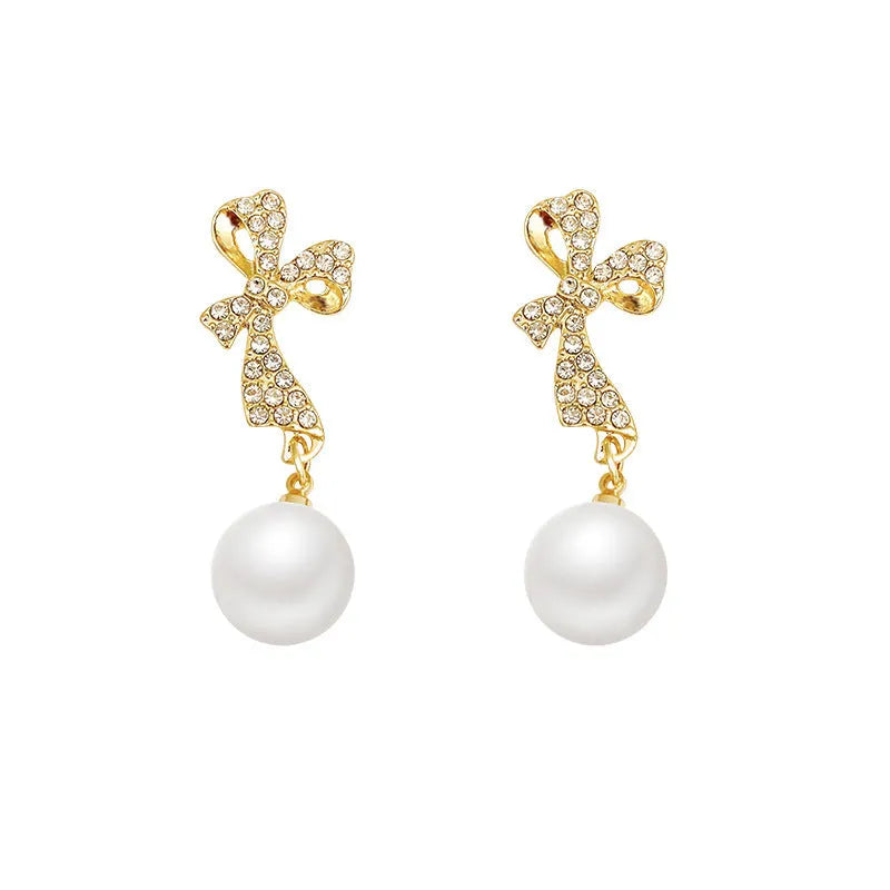 Gold butterfly earrings with rhinestones and bow element on alloy base