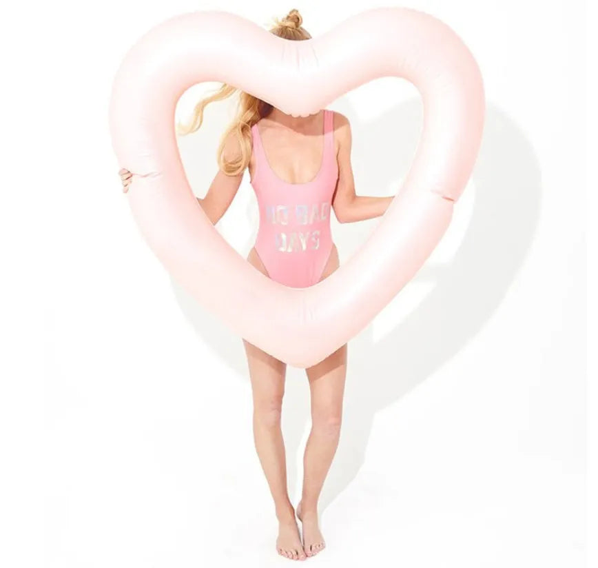 Oversized 120cm heart shaped swim ring in pink floating on water, adult outdoor pool toy