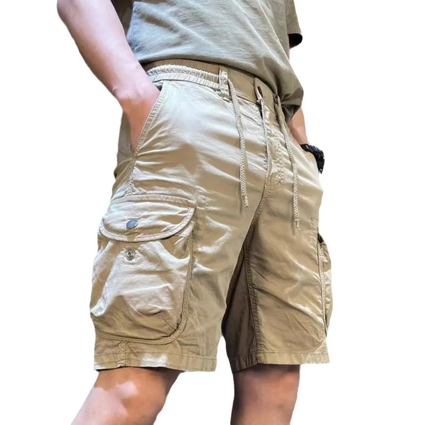 Loose straight-leg multi-pocket casual overalls trousers in khaki colour on a hanger.