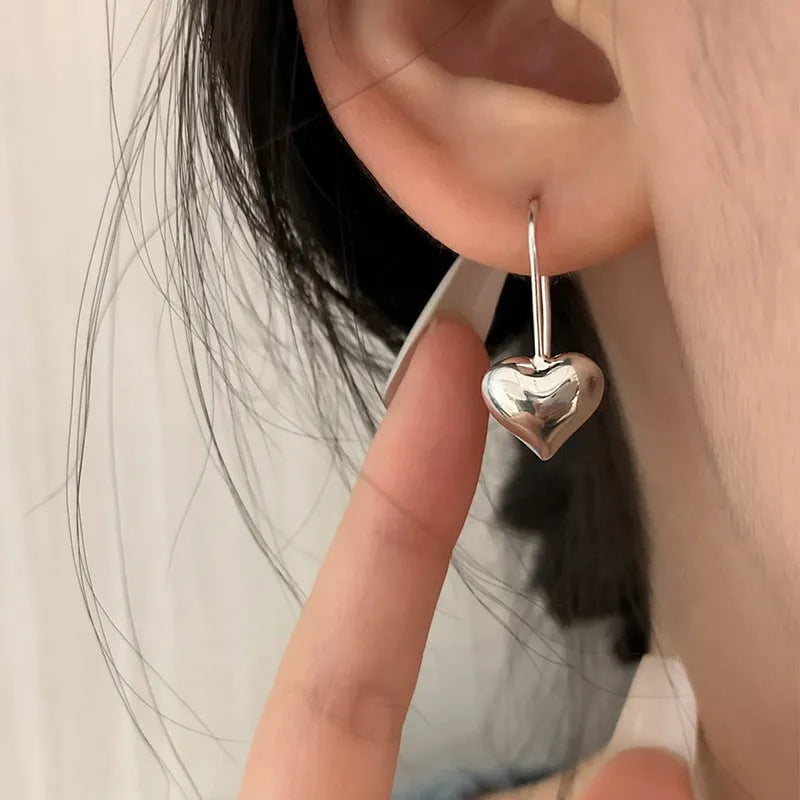 Silver heart-shaped women's earrings with glossy finish and three-dimensional design