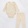 Newborn baby cotton romper two-piece suit in neutral style with top, pants, and matching hat on a white background
