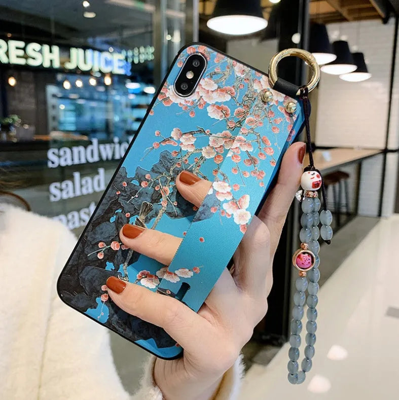 Rose flower design iPhone case with a white wrist strap attached, shown on an iPhone 11.