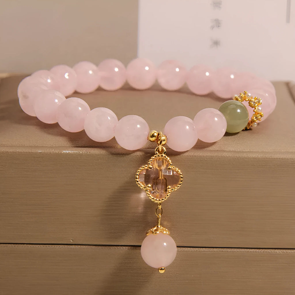 Pink crystal bracelet for women with a four-leaf clover pendant and sparkling rhinestones.
