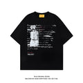 Man wearing a black loose-fit cotton T-shirt with a white printed letter pattern and raglan short sleeves.