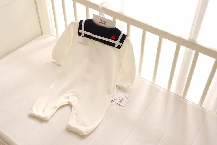 Navy cotton baby onesie with long sleeves and detachable hood on white background
