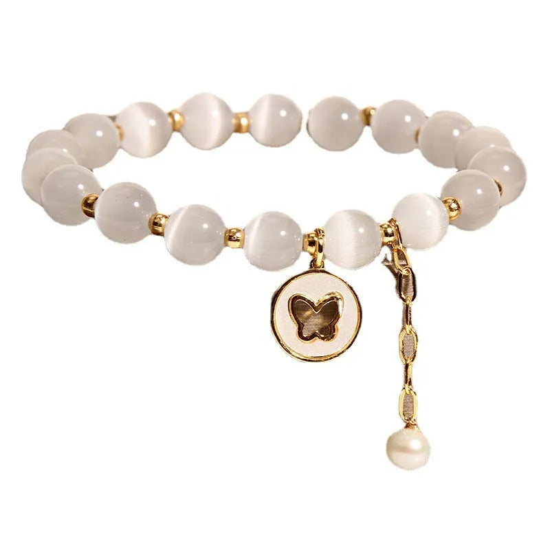White Cat's Eye crystal bracelet with geometric links on a wrist.