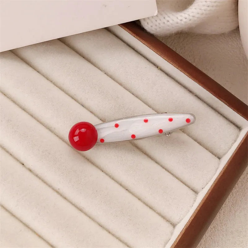 Red love heart-shaped plastic hair clip with retro dots and a willow leaf silhouette on a white background.