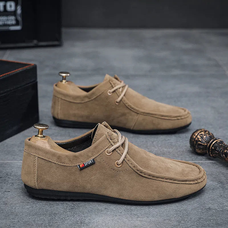 Men's black slip-on loafers with soft sole, round toe, and stitching detail on a neutral background