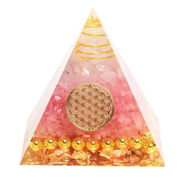 Clear epoxy resin pyramid ornament with natural crystal gravel inside on a wooden surface.