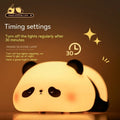 Cartoon panda rechargeable night light with soft silicone body on a wooden table