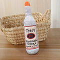 Brown plush dog toy shaped like a wine bottle with squeaker for chew play