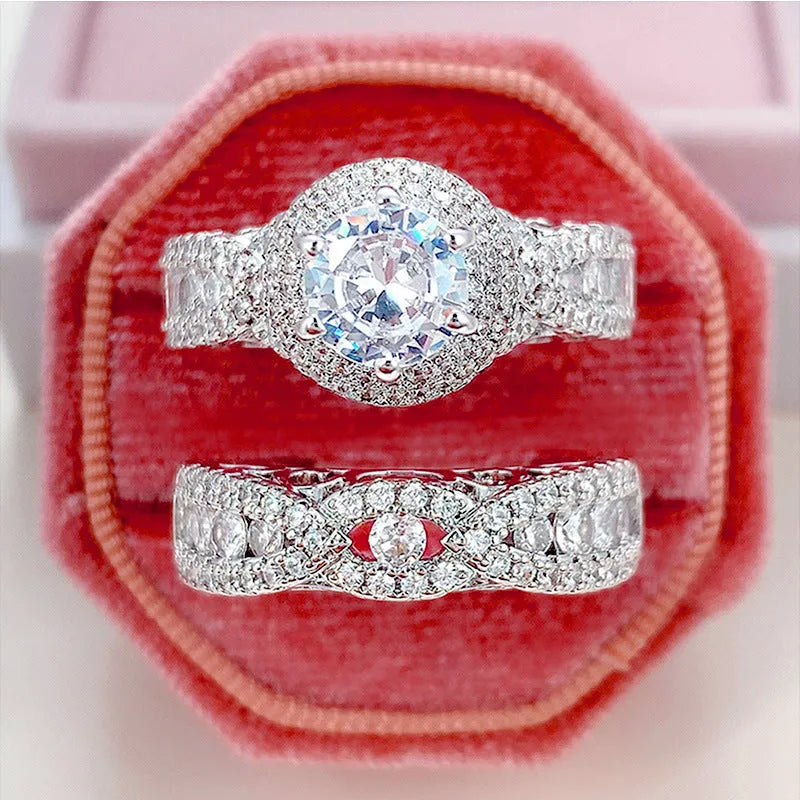 Pair of white gold colour copper couple rings with inlaid zircon stones, geometric U-shaped design on white background