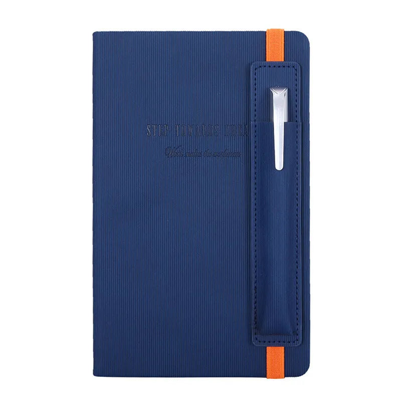 A5 faux leather notebook with pen insert and strap, open on a desk showing lined pages