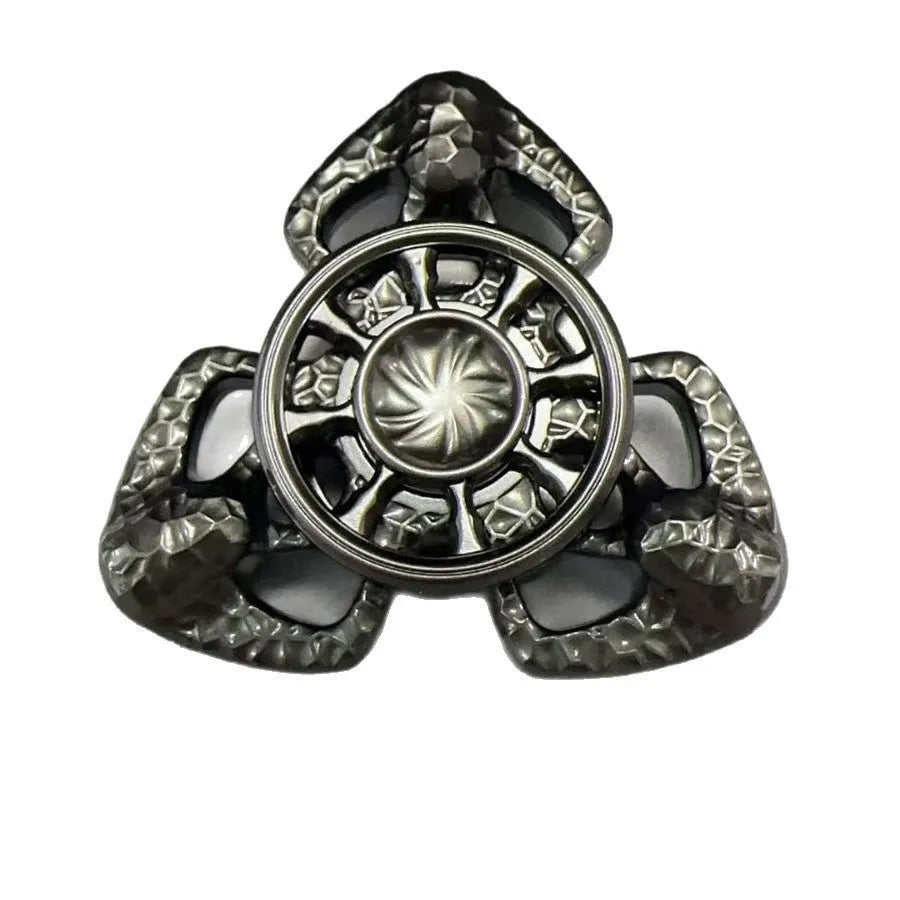 A metal butterfly-shaped fingertip gyro fidget toy spinning on a surface.