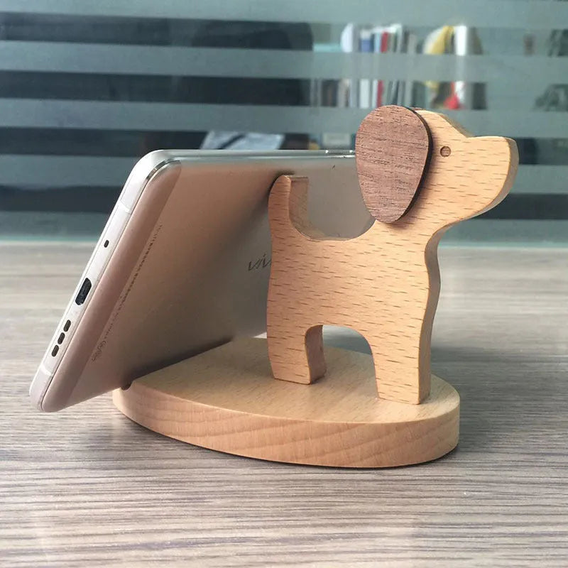 Beech wood and resin lazy bracket mobile phone holder in an animal design style on a desk.