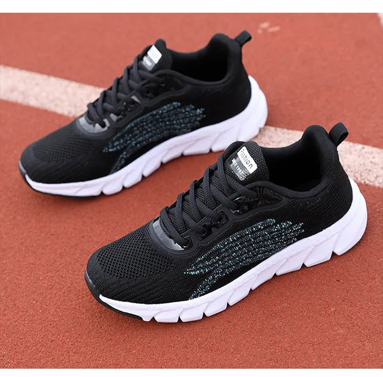 Women's low-top platform running sneakers in black and white colours with round toe and cross strap design