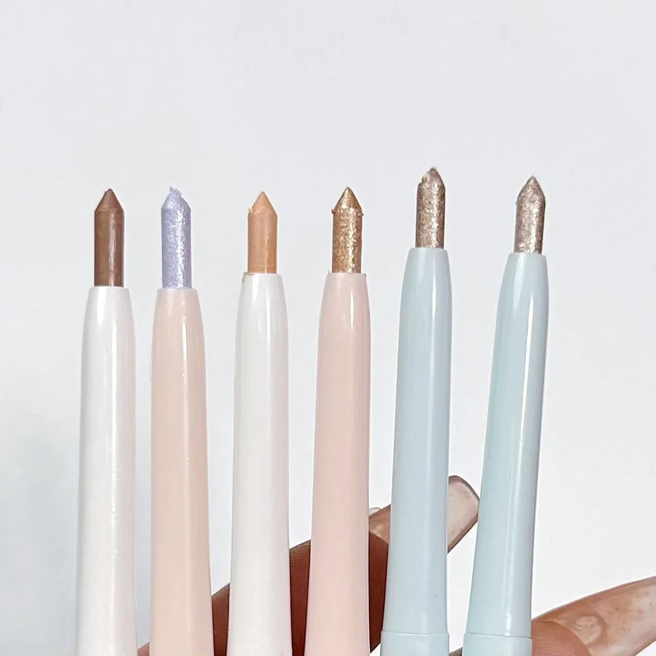 INS style 2-in-1 waterproof eye shadow pen in a selection of 14 brightening colours on a white background.