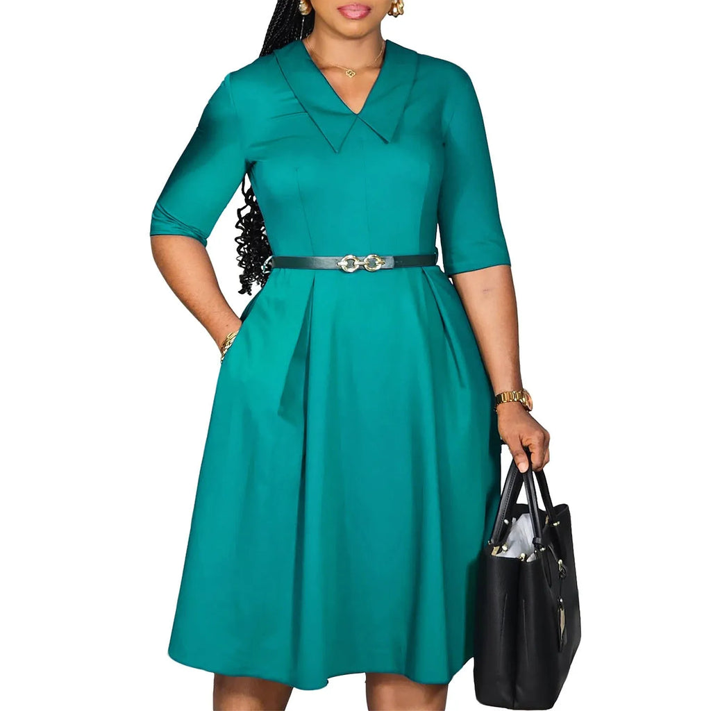 A woman wearing a solid colour African dress with half sleeves and a matching belt, showcasing the high-waist design.