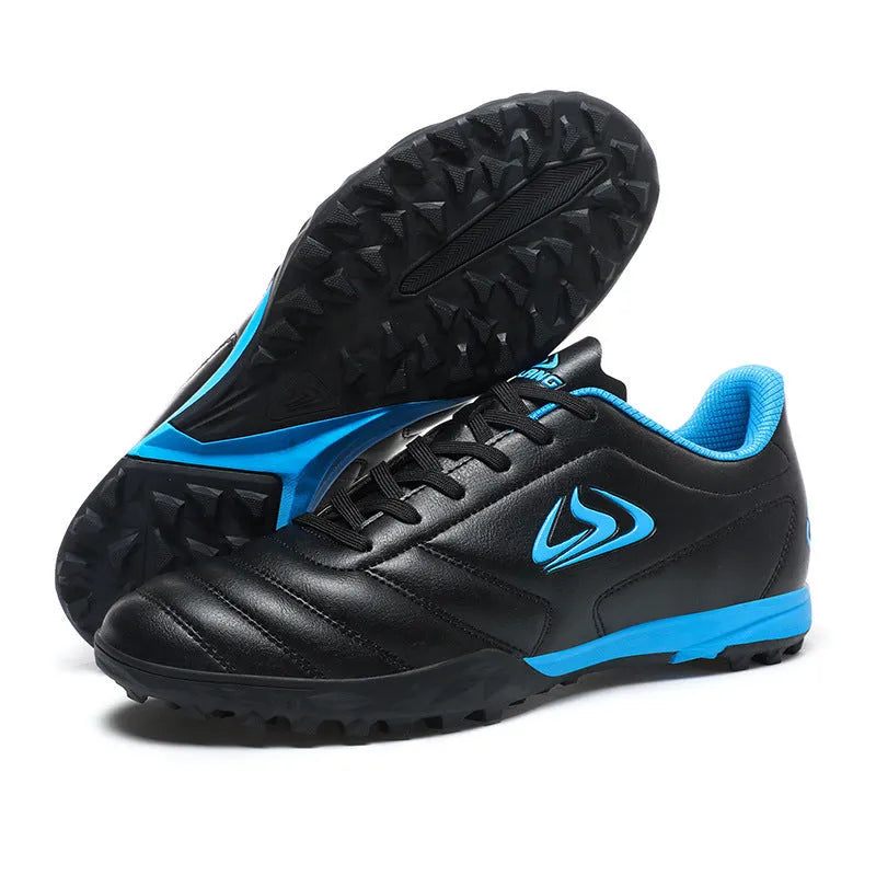 Low-top outdoor soccer shoes in a black and blue broken nails colourway on a turf background.