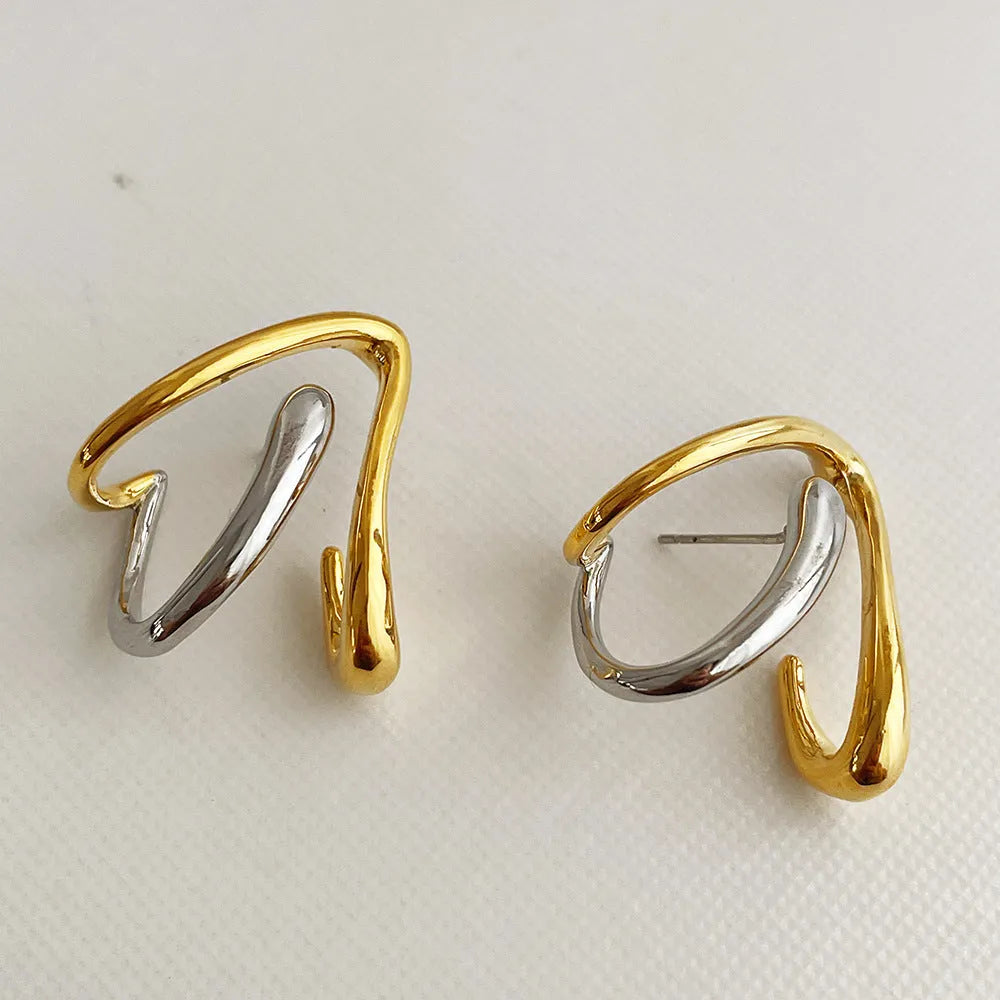 Gold and silver irregular triangle alloy stud earrings with sterling silver needle on neutral background