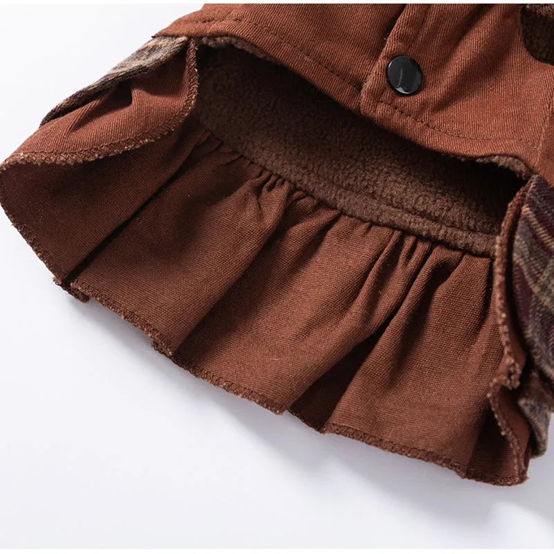 Fleece-lined brown plaid pet sweater dress with ruffle trim on a small dog, showing stretchable knit and skirt silhouette