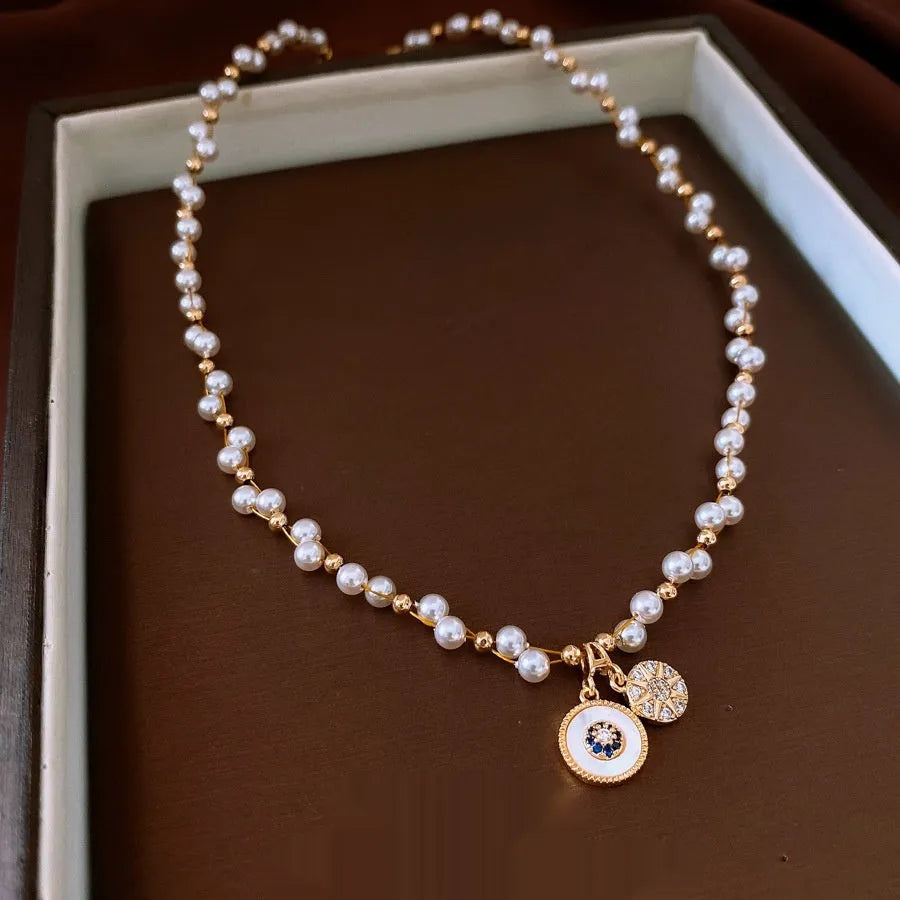 Gold electroplated zircon and imitation pearl pendant necklace on adjustable clavicle chain