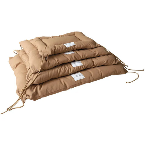Beige pet cage cushion secured inside a metal dog crate, showing tie straps.