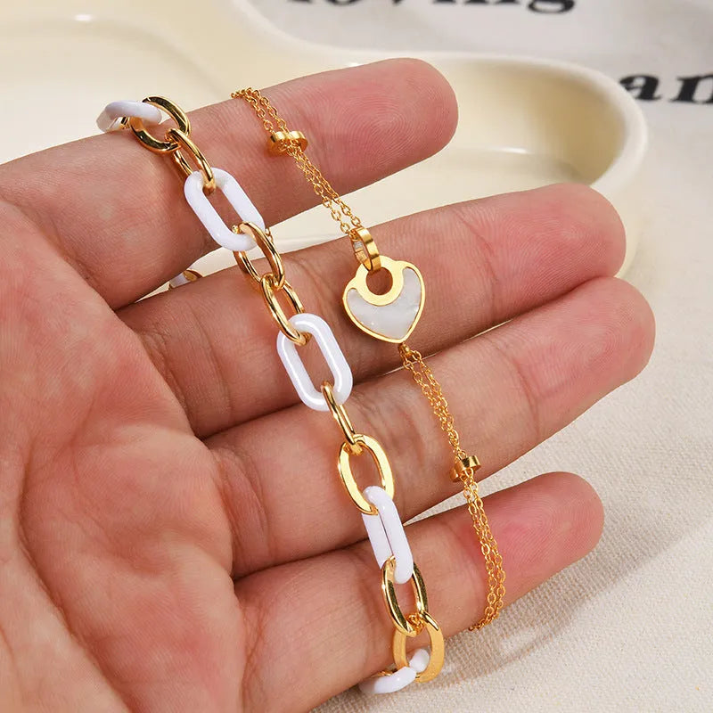 Stainless steel bracelet for women with a double-layered red resin heart charm on a metallic chain.