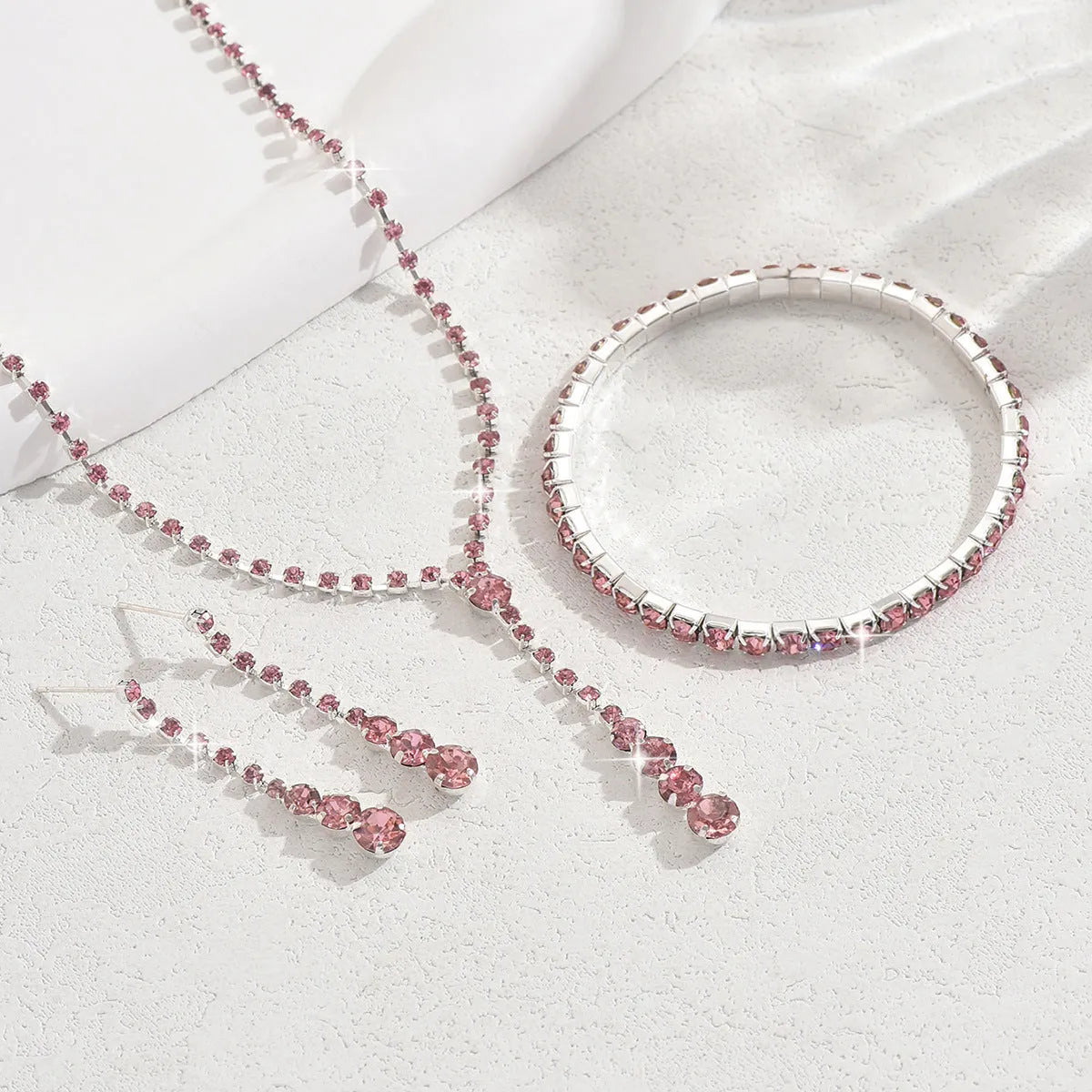 Wedding jewellery three-piece set showing necklace, bracelet and earrings with rhinestone pendants