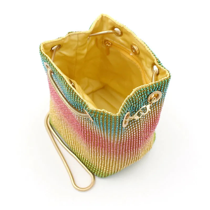 Rainbow coloured rhinestone bucket bag with an adjustable metal chain strap.