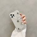 Clear iPhone case with transparent love heart bracelet charm attached, showing soft TPU material.
