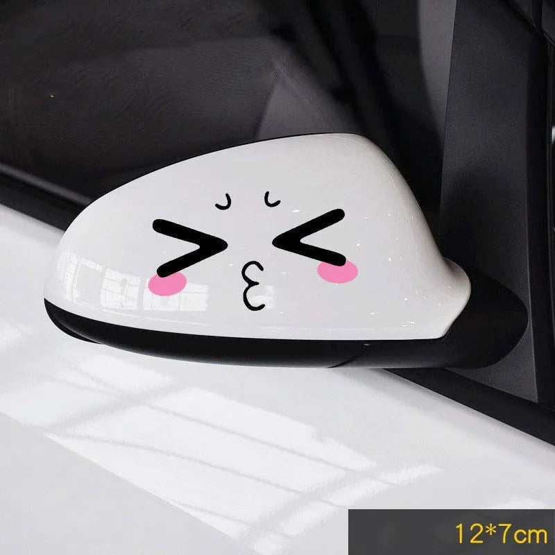 Pair of reflective cartoon eye car stickers on a vehicle rearview mirror.
