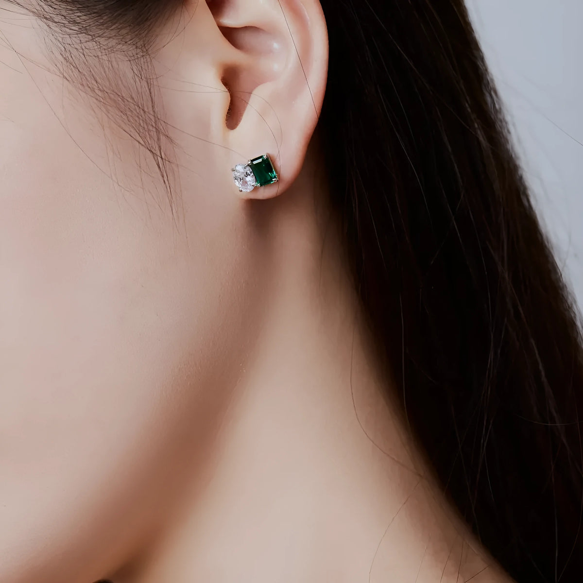 Silver stud earrings with emerald green stone in geometric ellipse and quadrilateral shape