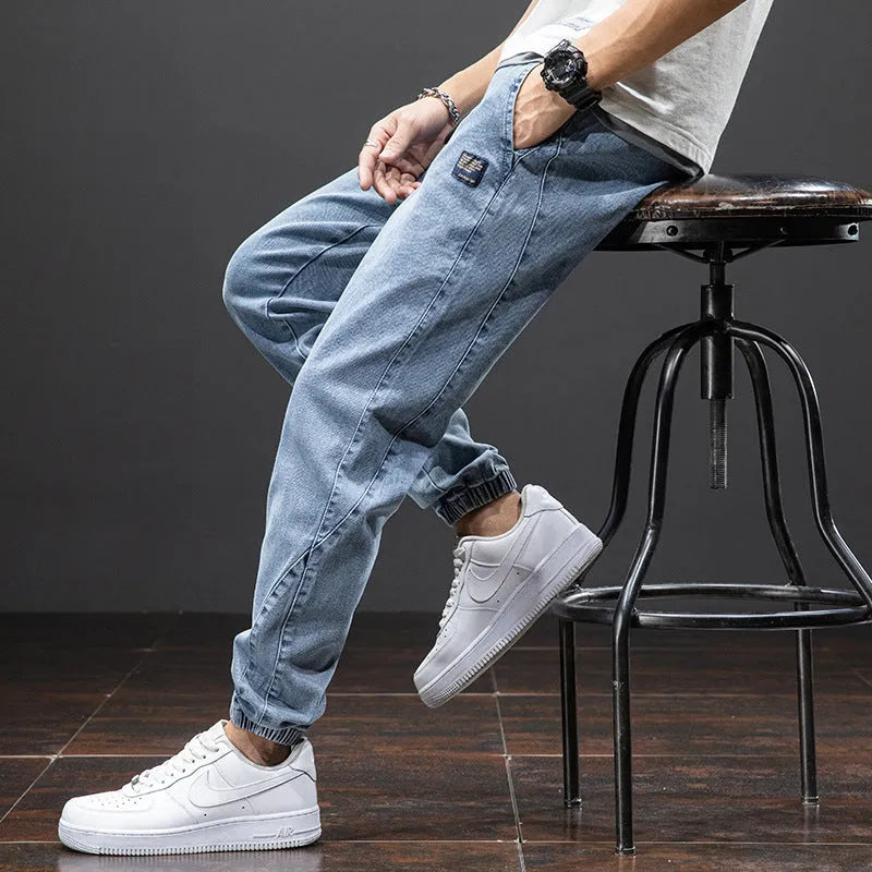 Men's loose straight-leg cargo casual jeans in blue, showing cargo pockets and mid-waist fit.