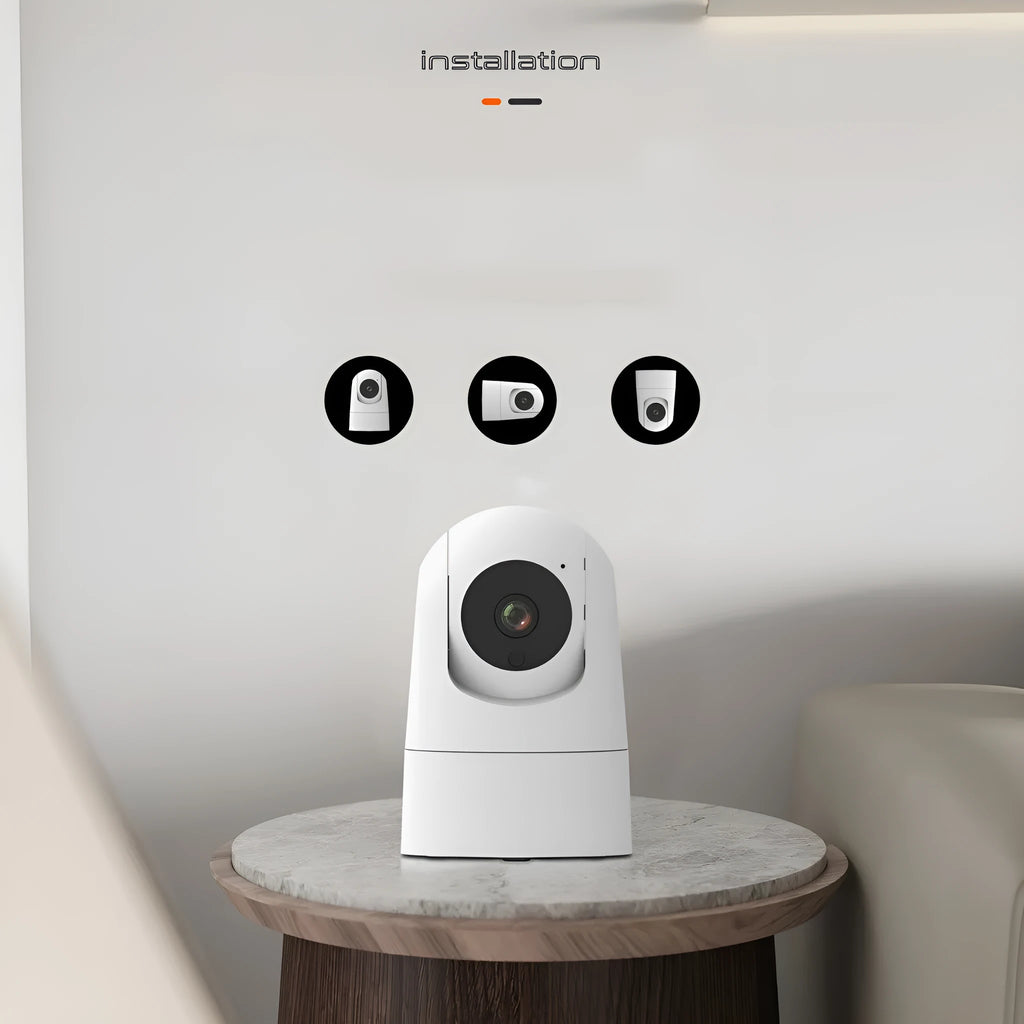 White indoor pan-tilt security camera with wide-angle lens on a desk.