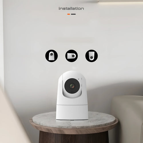 White indoor pan-tilt security camera with wide-angle lens on a desk.