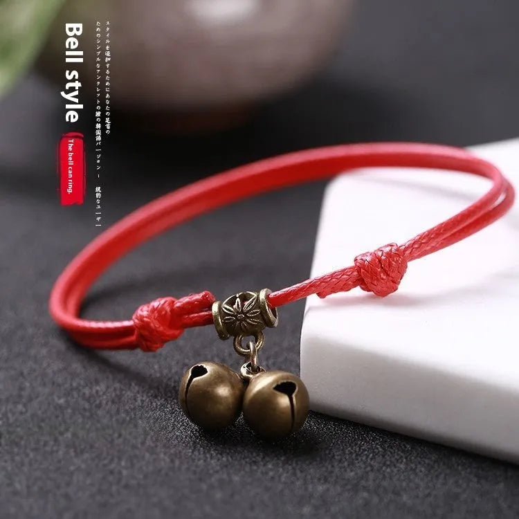 Adjustable black nylon dog collar with a brass bell for a small pet.