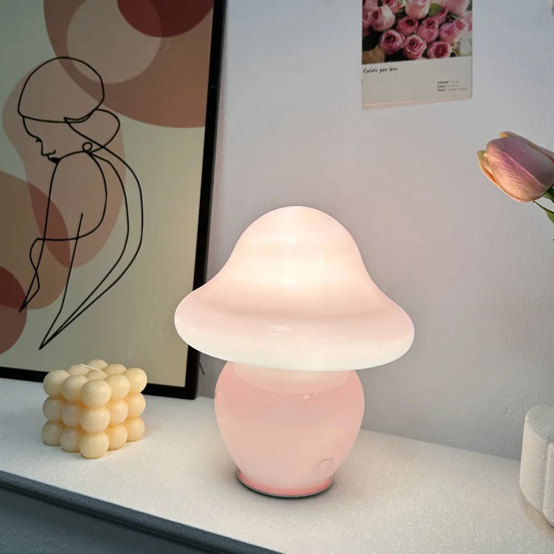 Glass mushroom decorative lamp with three-colour light in orange smooth finish on a wooden table