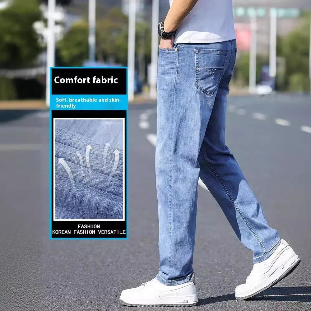 A pair of tapered fit stretch denim trousers in a light blue colour, laid flat.