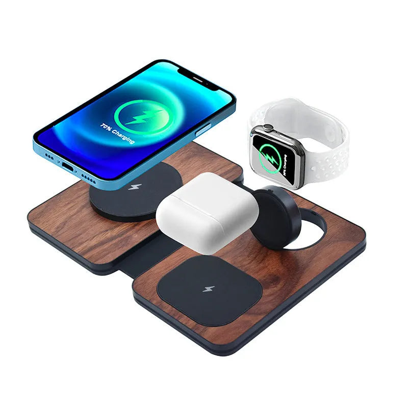Three-in-one foldable magnetic wireless charger with walnut base and stand, charging a phone, earbuds and watch.