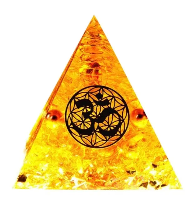 Clear epoxy resin pyramid ornament with natural crystal gravel inside on a wooden surface.