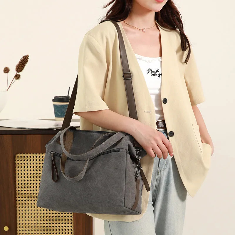 Large khaki retro canvas shoulder bag for women showing external sandwich pocket and internal organiser compartments.