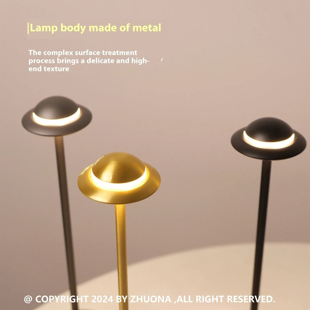 Black UFO-shaped metal table lamp with rechargeable battery and touch dimming controls.
