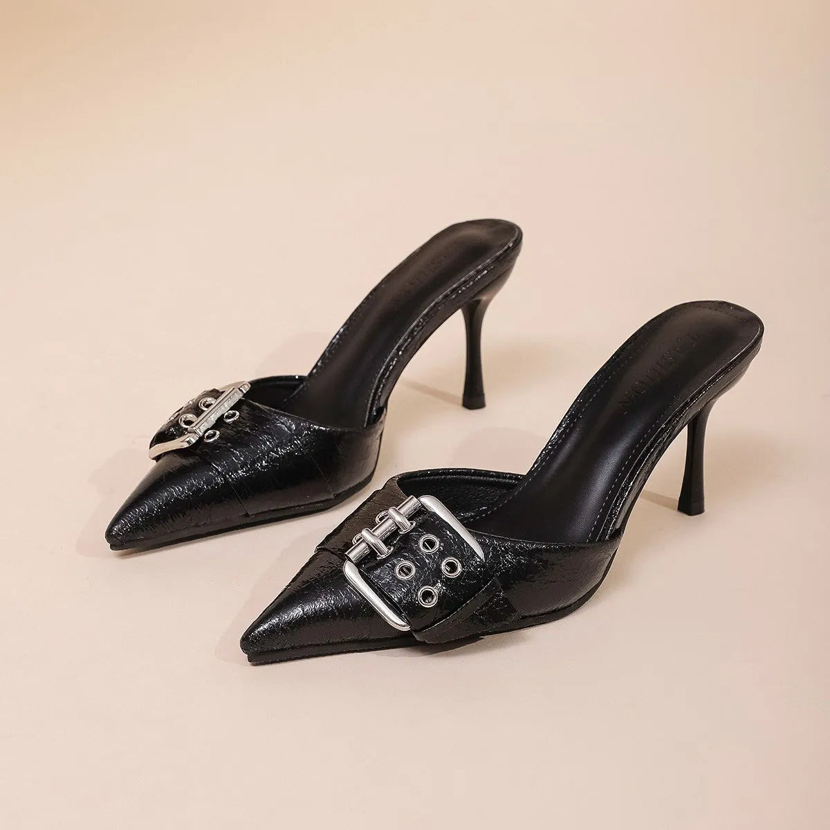 Black women's pointed toe high heels with a strap and buckle closure.
